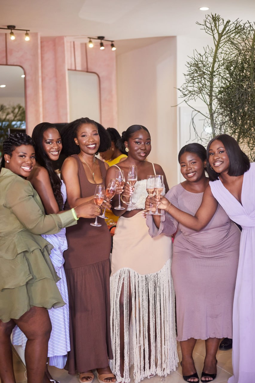 Six women raising rosé flutes together at the end of Edition 1