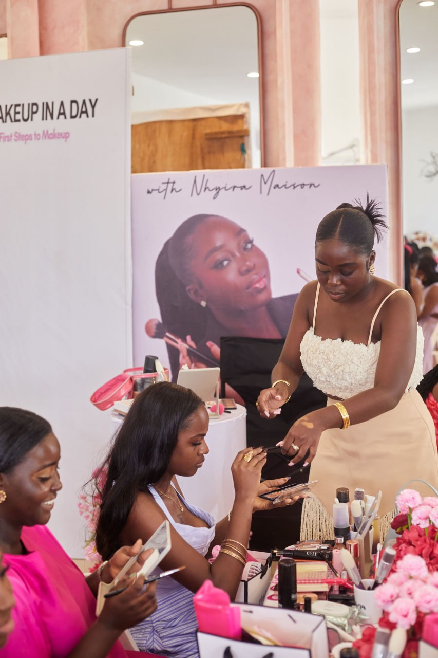 Nhyira walking the room helping an attendee with her palette