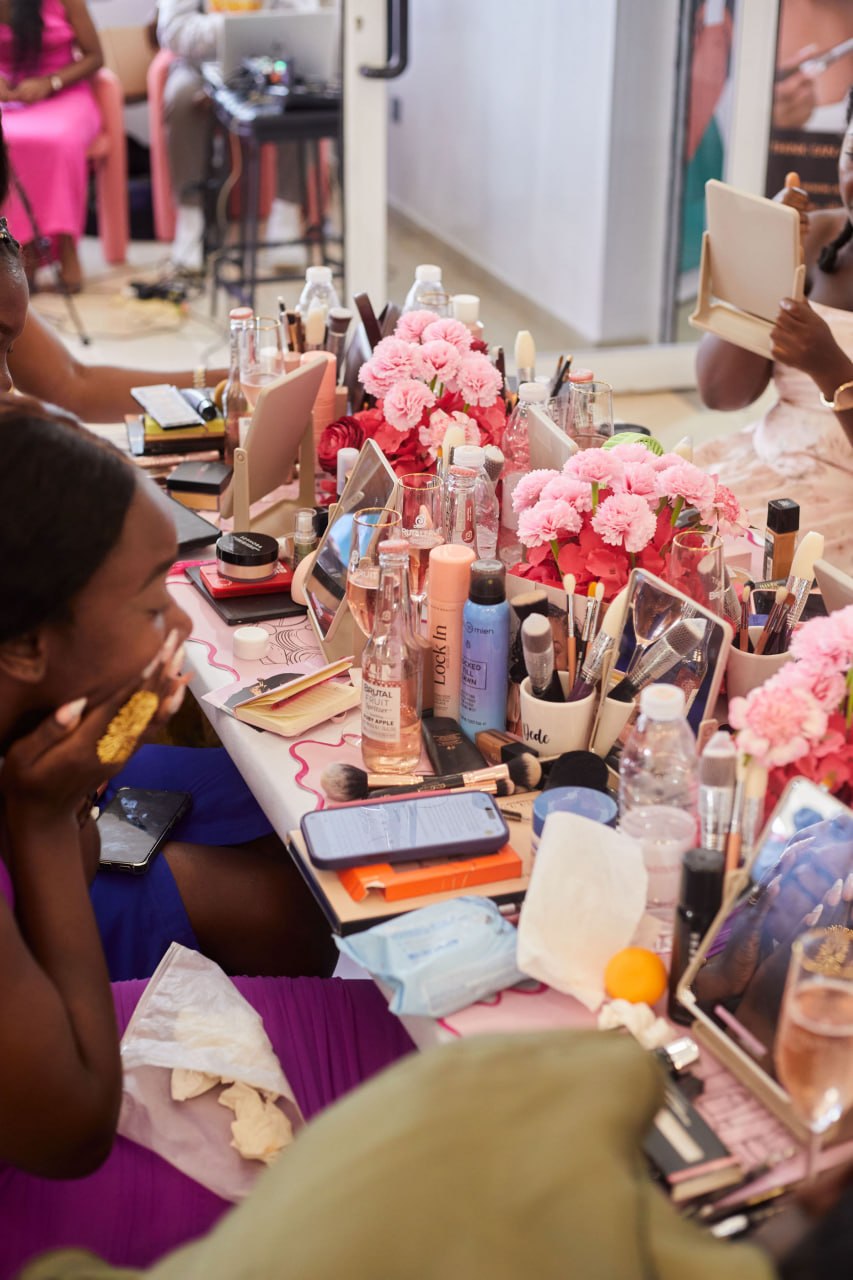 Attendees working at a table covered in product, brushes and pink carnations